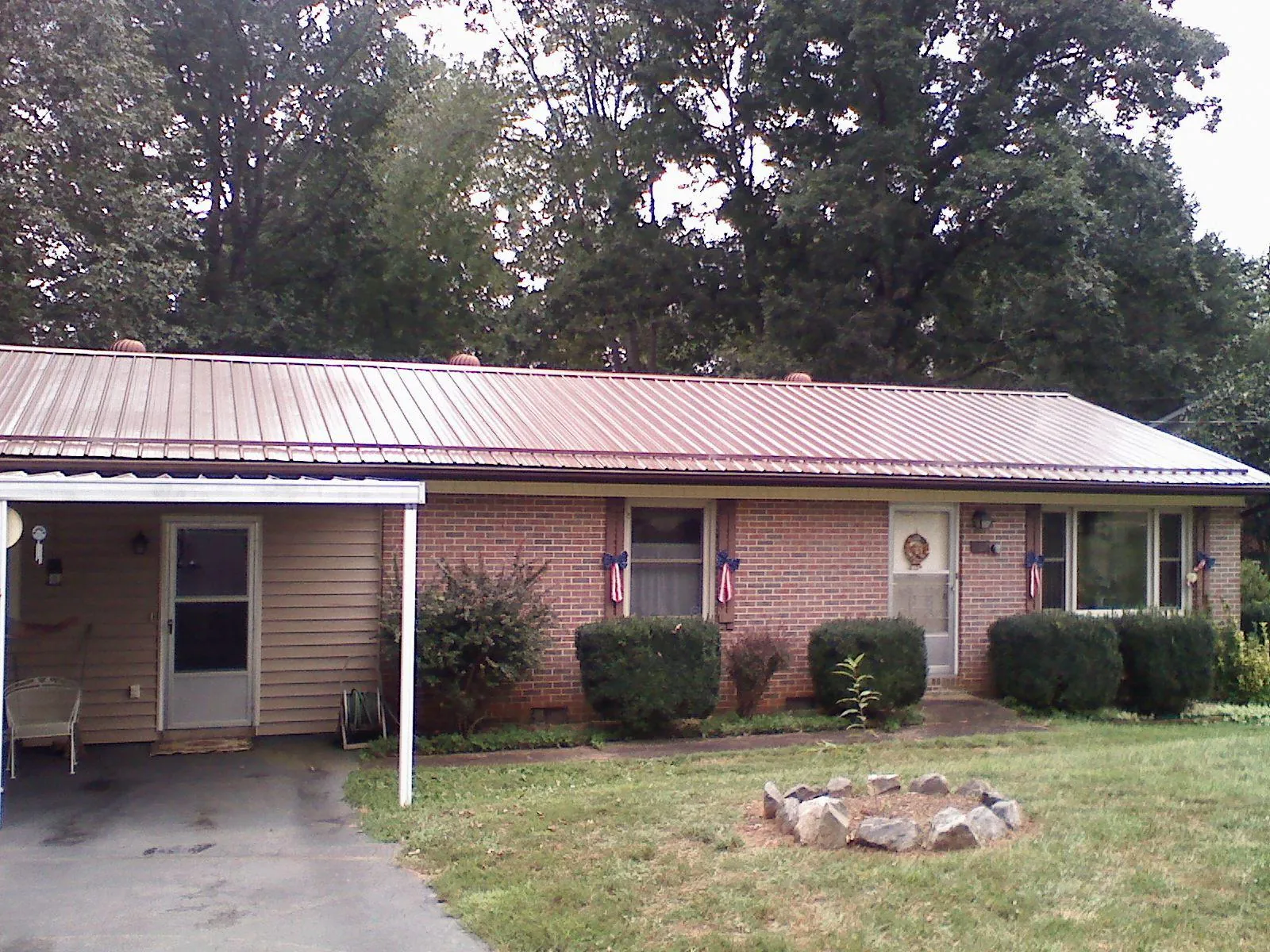 Bronze metal roof and carport on a brick ranch home — Roof Repair work by our crew in Hallam
