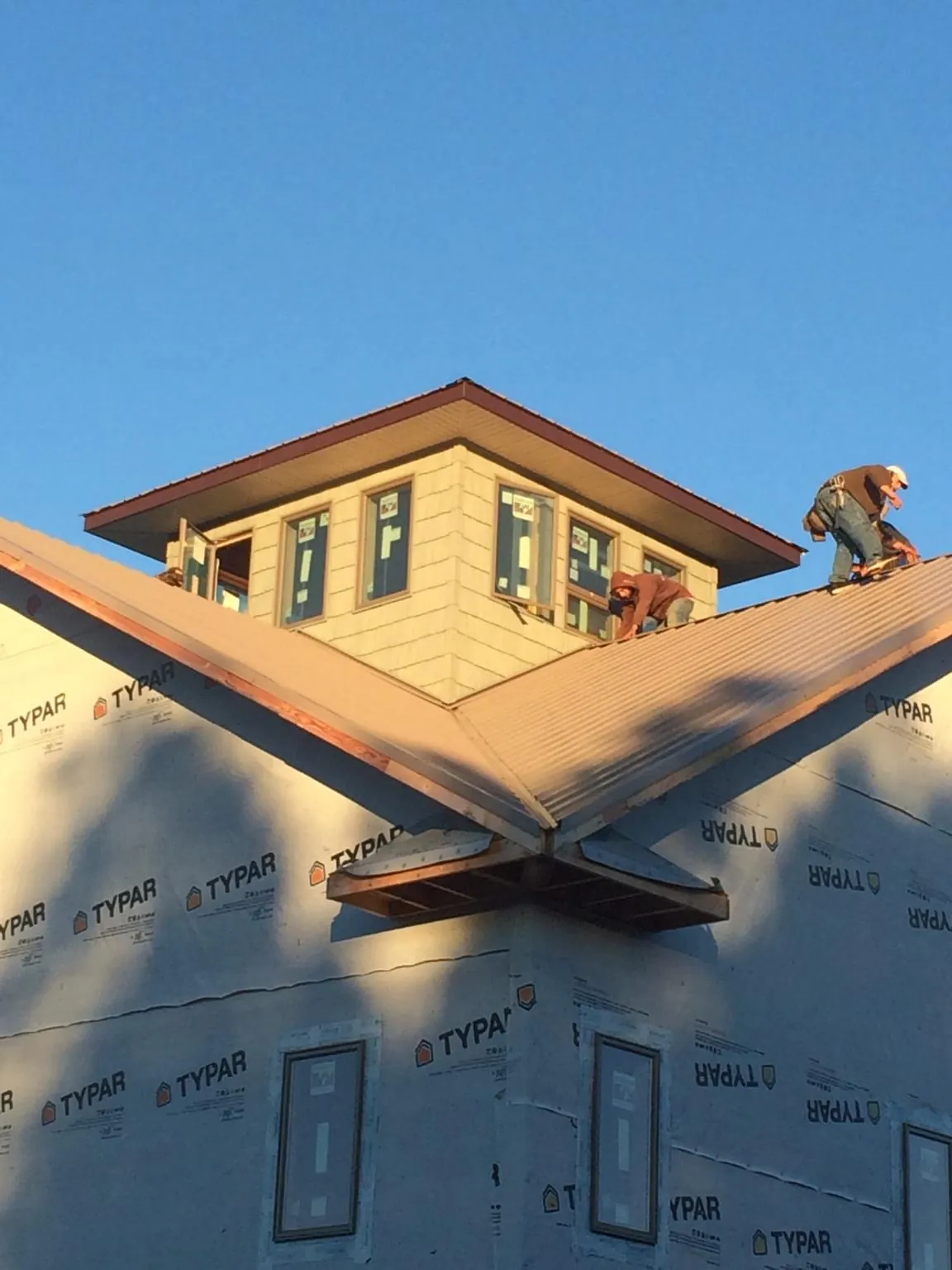 Roofers working around a rooftop cupola on a new metal roof at sunset — Roof Waterproofing in Hallam by Roofing Brothers